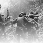 A group of men in the woods fighting.